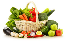 raw vegetables in wicker basket isolated on white